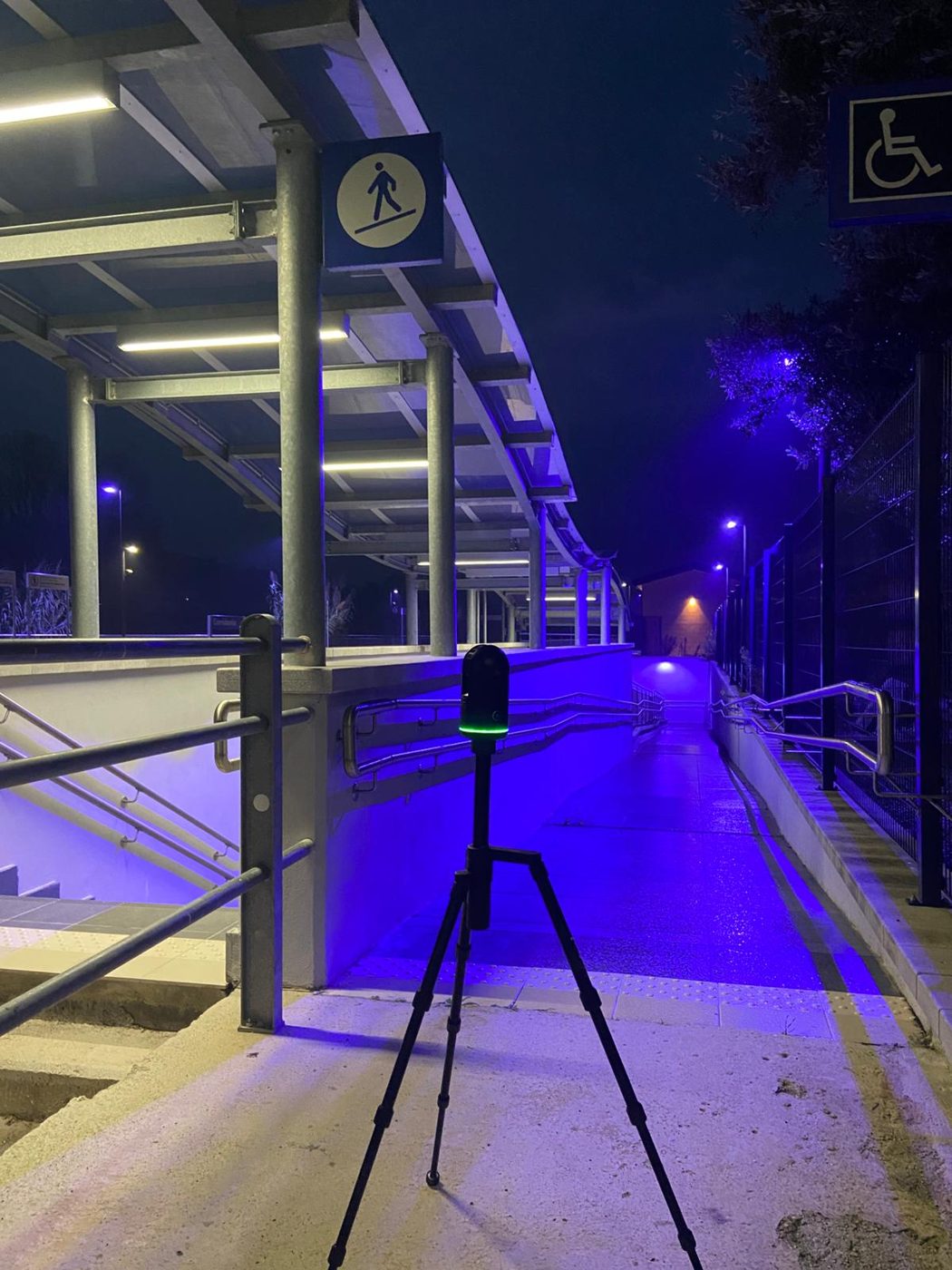 Scanner in postazione su una passerella di stazione, di notte